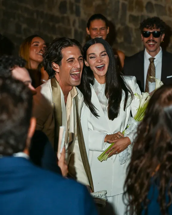 Dove Cameron holding her bouquet surrounded by wedding guests in Montalcino